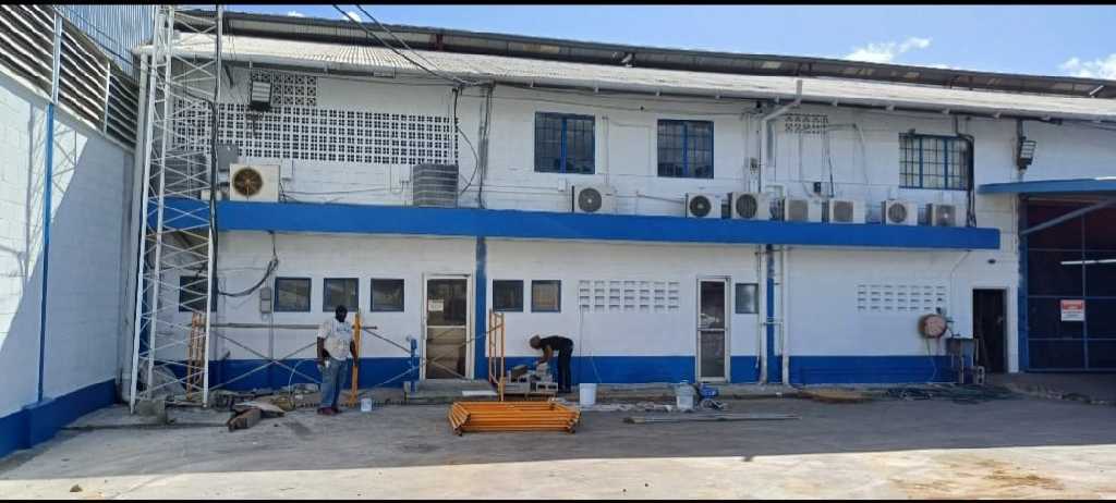 Workers and scaffolding at a commercial building during exterior painting work.